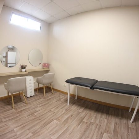 Sala multiusos con dos tocadores y camilla.